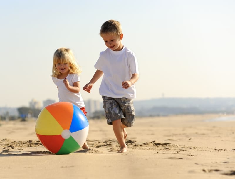 Fun Things to do at the Beach with Family two kids on beach with ball